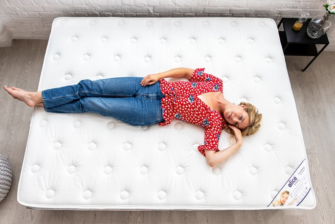 Femme allongée sur un matelas en mousse posé au sol